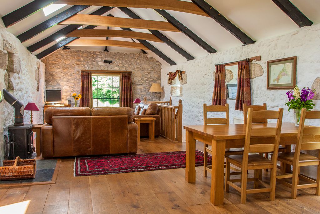 Upstairs living area at the Granary with a wood burner sofas and table