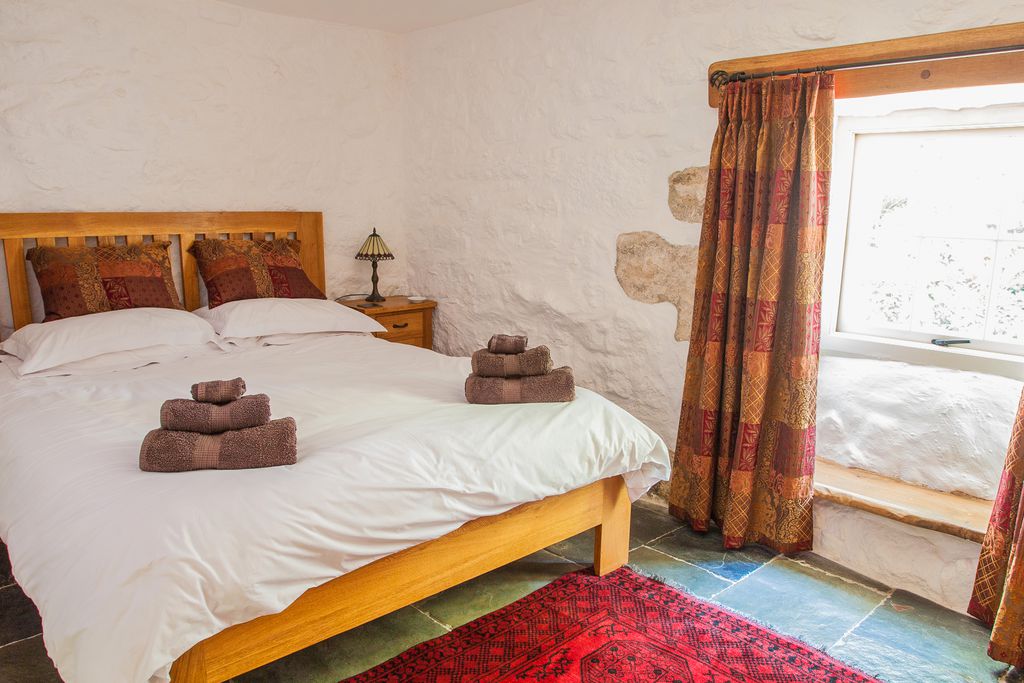 Double bed with towels and sun shining through the window