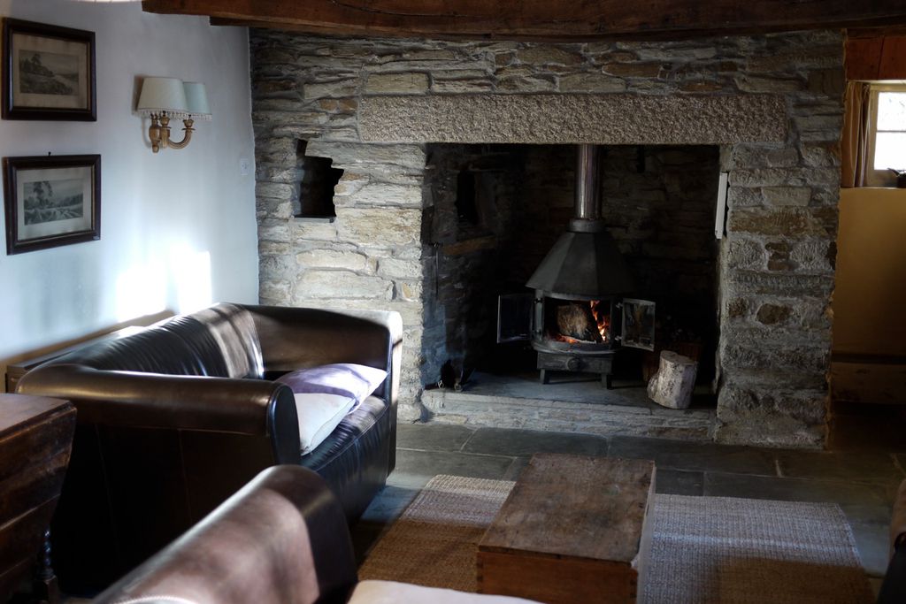 Living room with traditional stone walls and a log burner