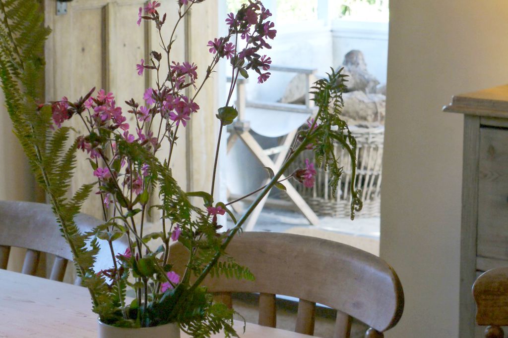 Flowers on the kitchen table with the back door of the property leading into the garden