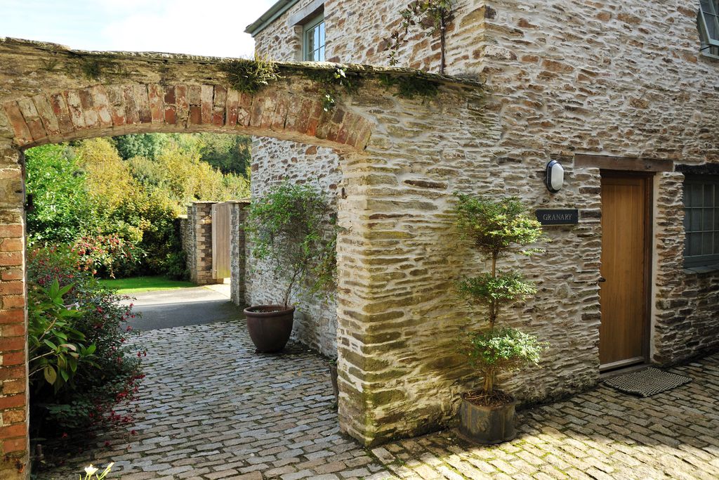 Exterior view of a cottage with the stone archway