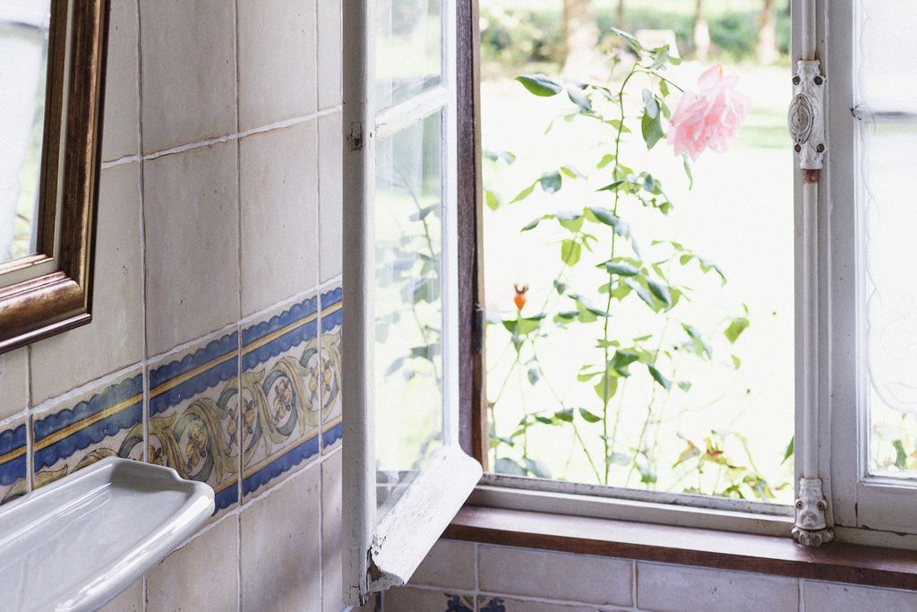 Bathroom with open window viewing out into garden