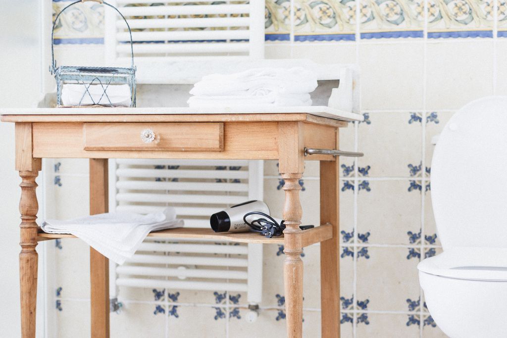 Table in bathroom with towels and hairdryer