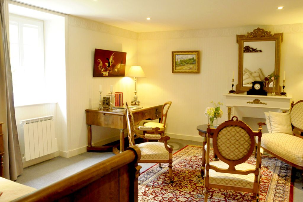 Double bedroom with table, chairs and paintings on the wall