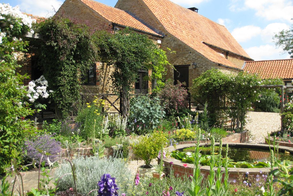 The Barn exterior with garden and pond