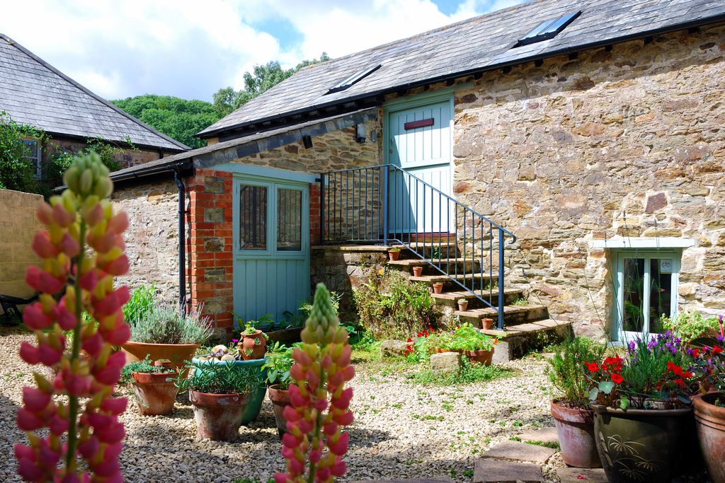 Exterior of The Granary in Cornwall with pretty plants and steps leading up to the front door