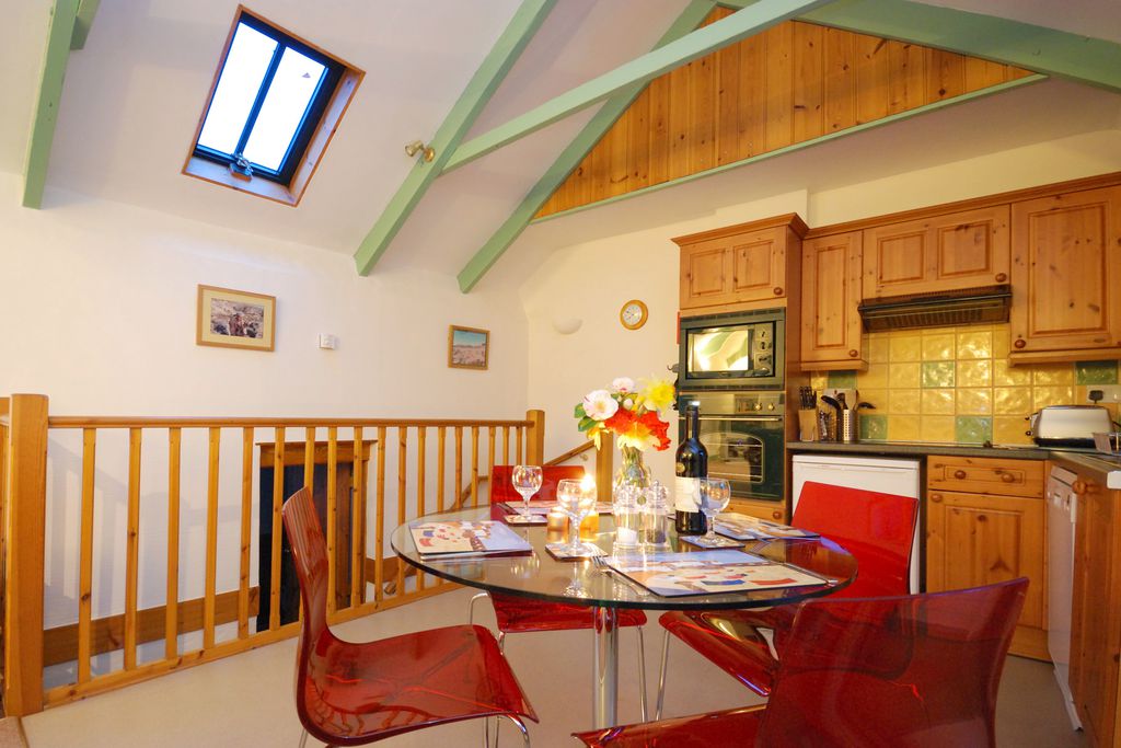Country-style upstairs kitchen with exposed beams and a table set for four