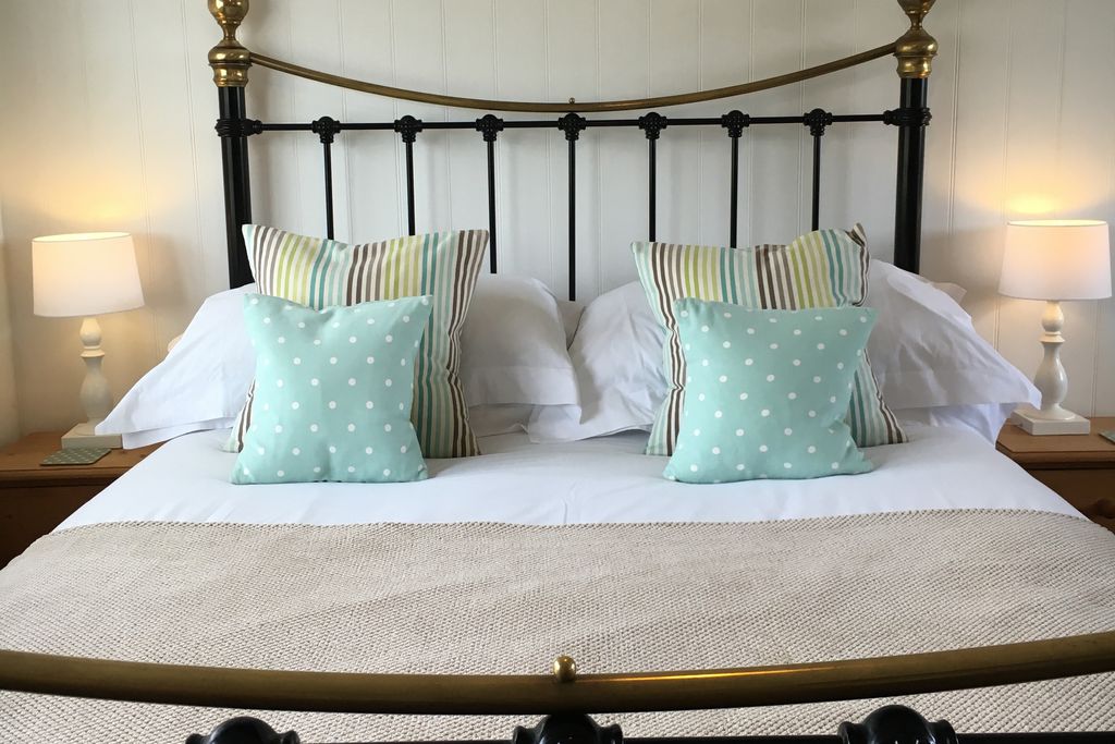 Cosy double bedroom with traditional wrought iron bed and colourful cushions