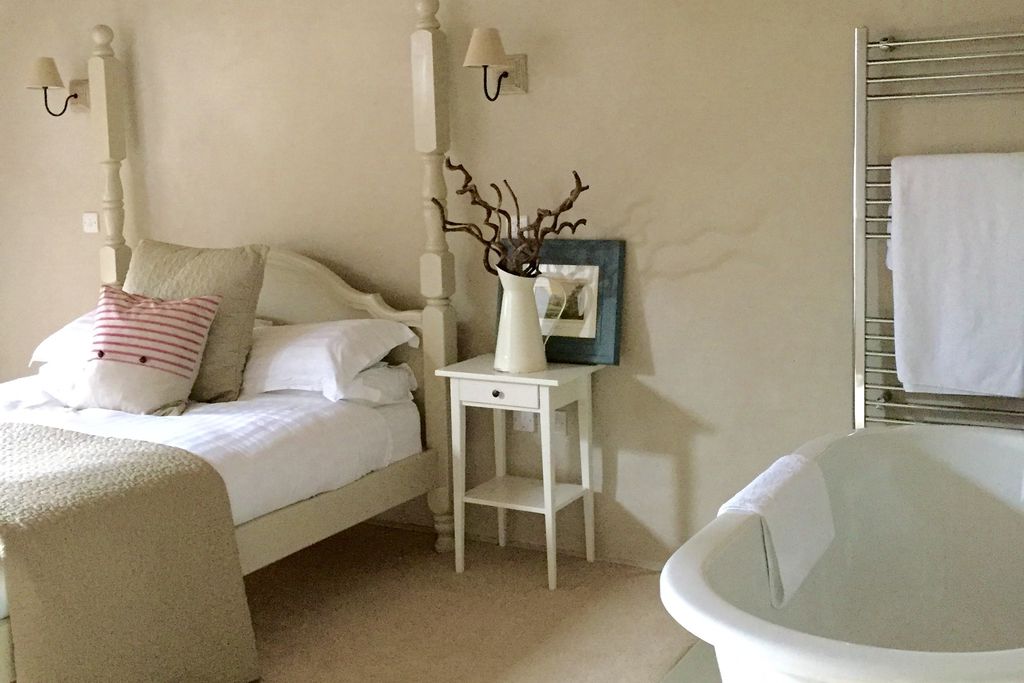 Light and airy bedroom at Winnow Nook, Derbyshire with large bath tub