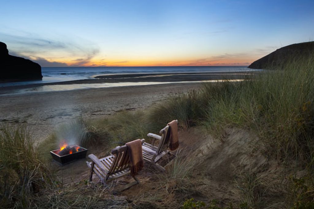 Deckchairs in the dunes with a bonfire
