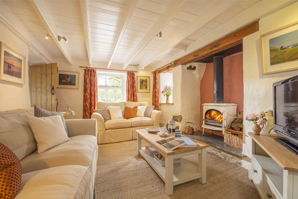 Cosy sitting room with log burner alight at Higher Grogley Farm in Cornwall