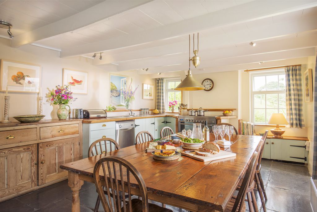 Large farmhouse style kitchen with dining table at Higher Grogley Farm