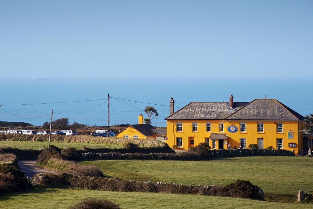 Exterior of The Gurnard's Head in Cornwall set in the countryside with view of sea just behind