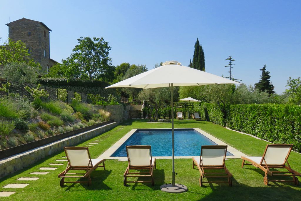 View of pool and seating area within the grounds of Torre di Sopra in Florence, Tuscany in Italy on a lovely sunny day