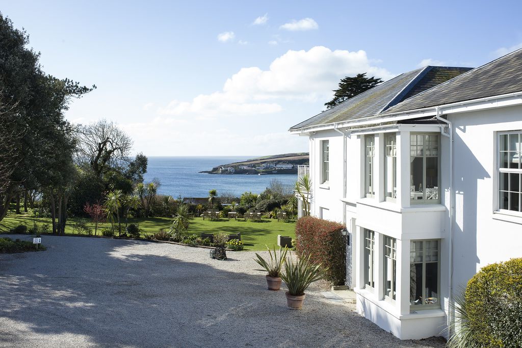 Exterior view of property with expansive lush garden and beautiful view of the sea