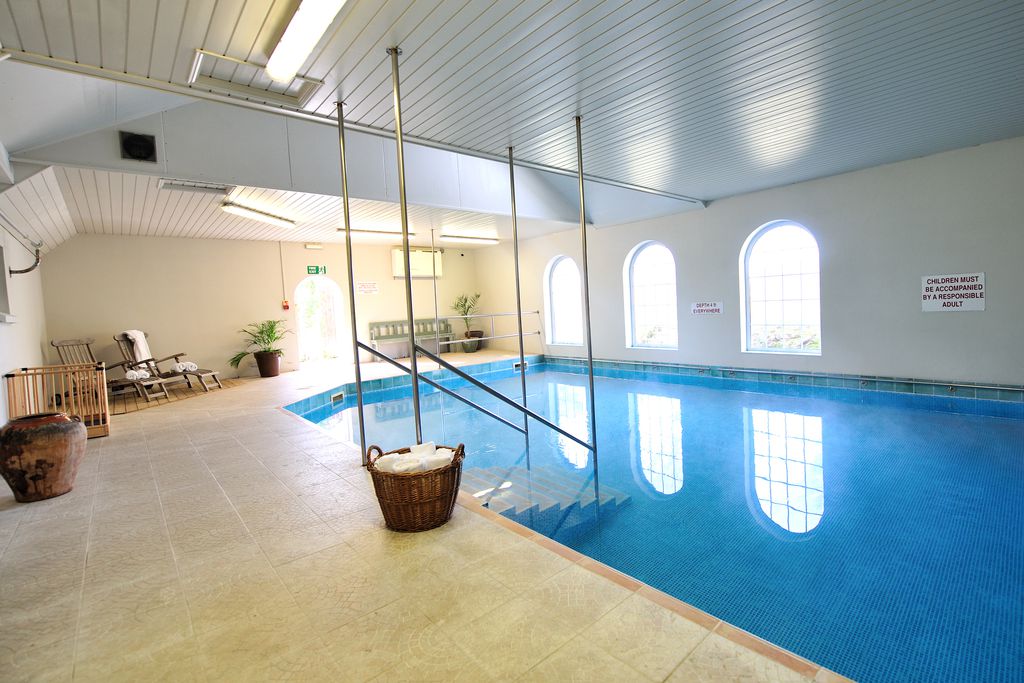 Indoor swimming pool with loungers to relax on