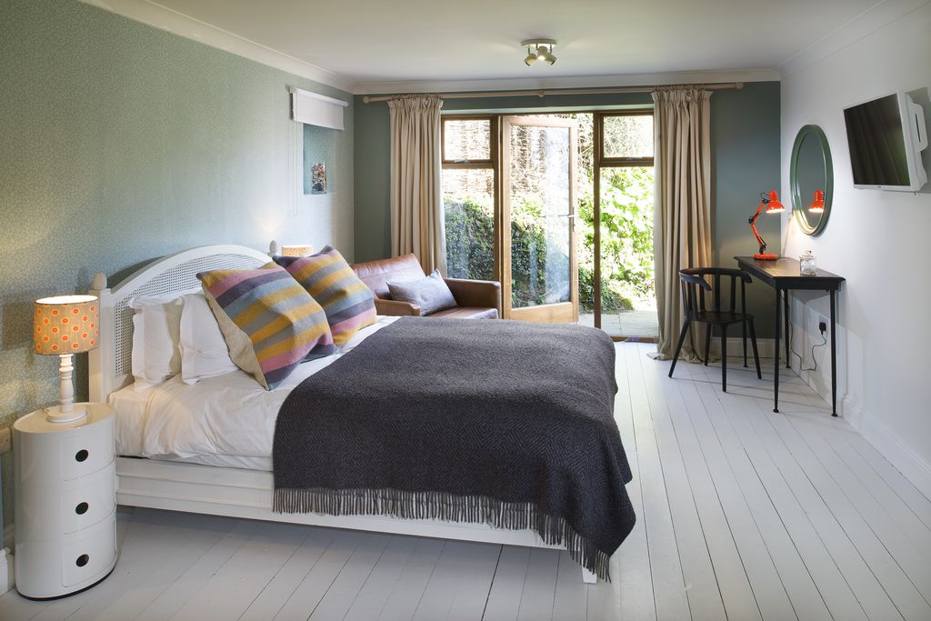 Light and airy ground floor bedroom with modern and colourful decor and doors out to the garden