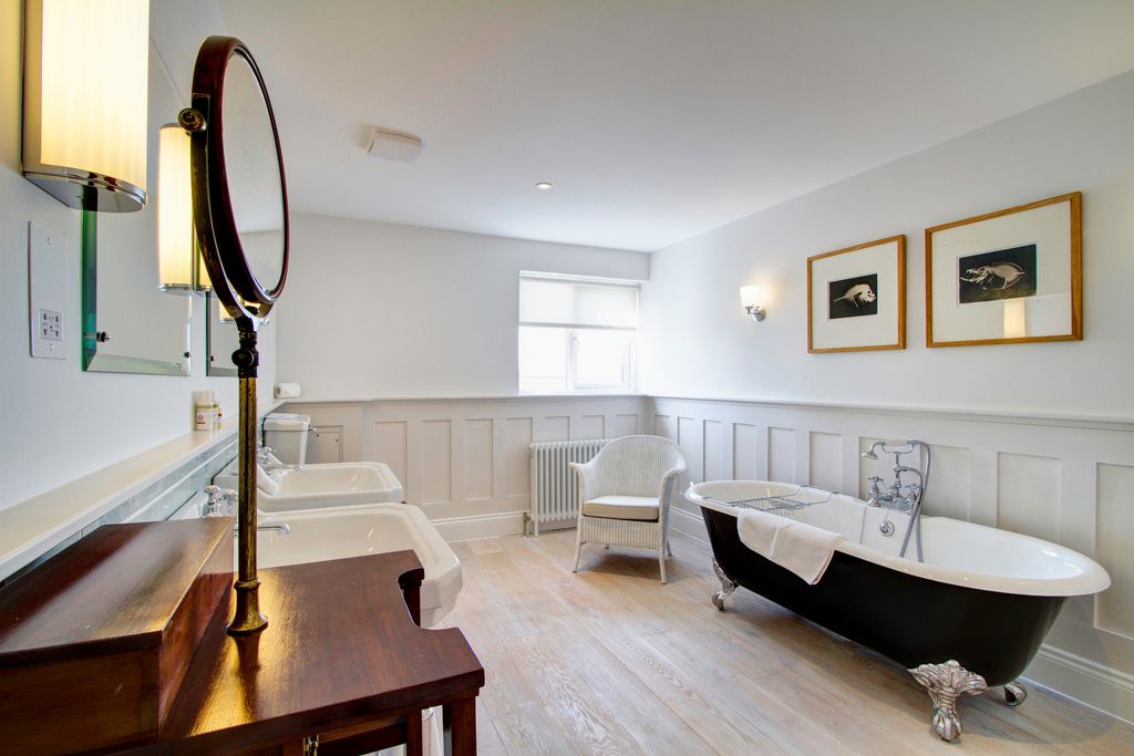 Large bathroom with traditional roll top bath tub