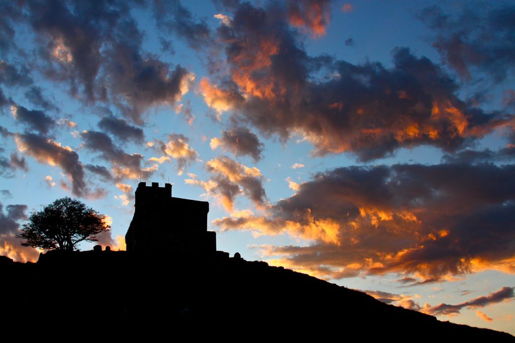 Silhouetted outline of the house with the sunset in the background