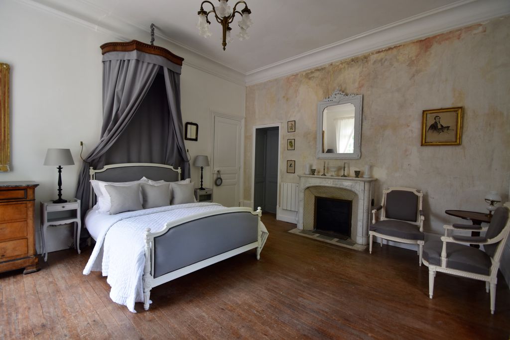 Spacious bedroom that has a neutral colour palette and king-size bed in Manoir de Plaisance