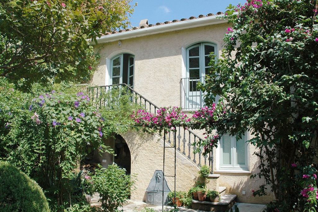 Exterior of Casa de la Fuente in Gerona, Catalonia, Spain with flowers climbing the building and steps leading up to entrance