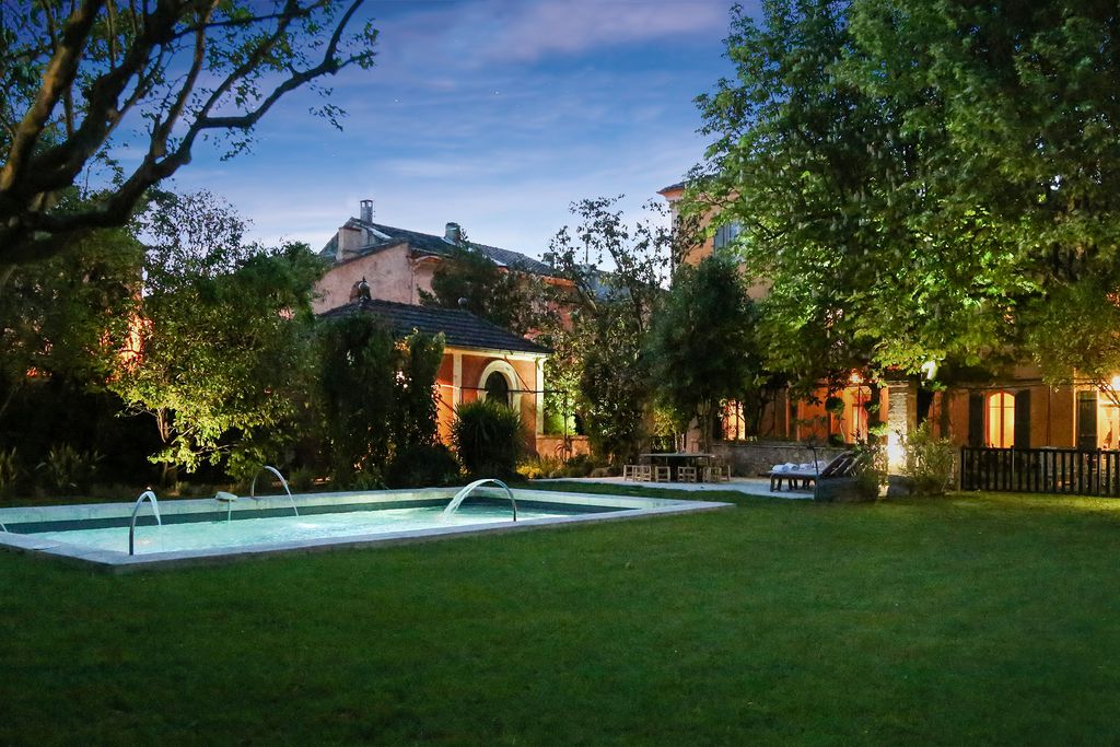 Le Mas De Graveson's back garden with outdoor swimming pool in the evening sun of Alpilles