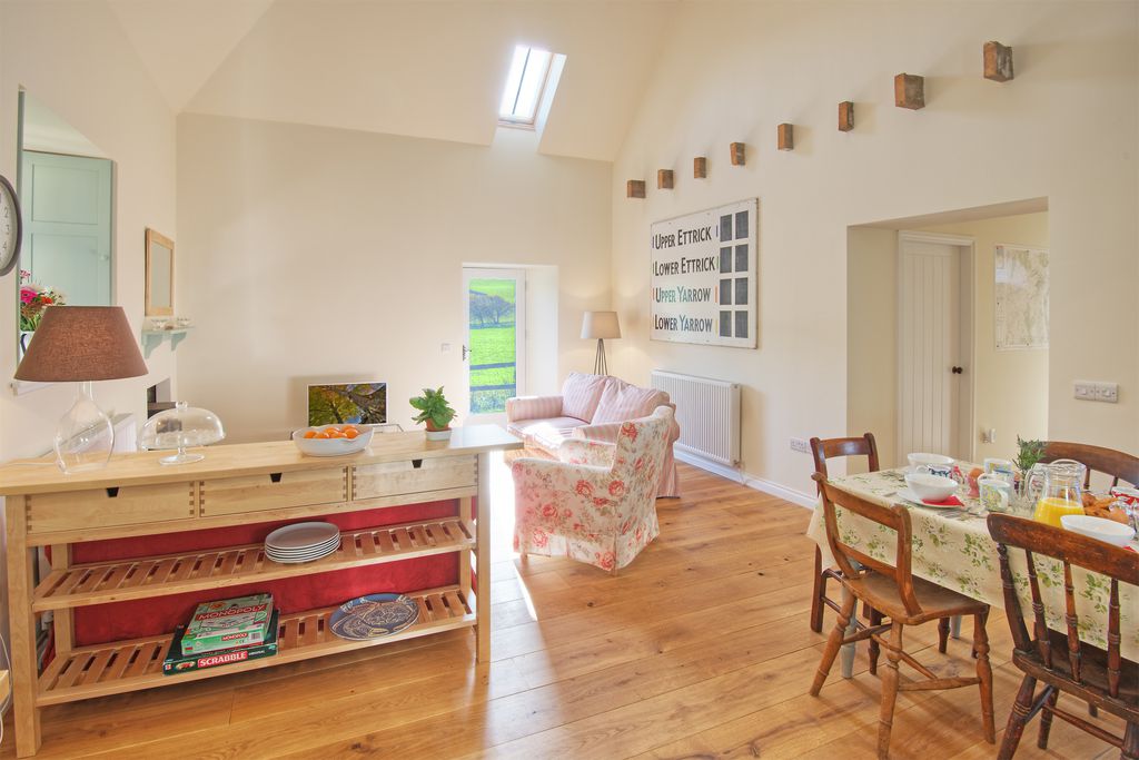 Open plan living room and dining area separated by a sideboard with board games on it