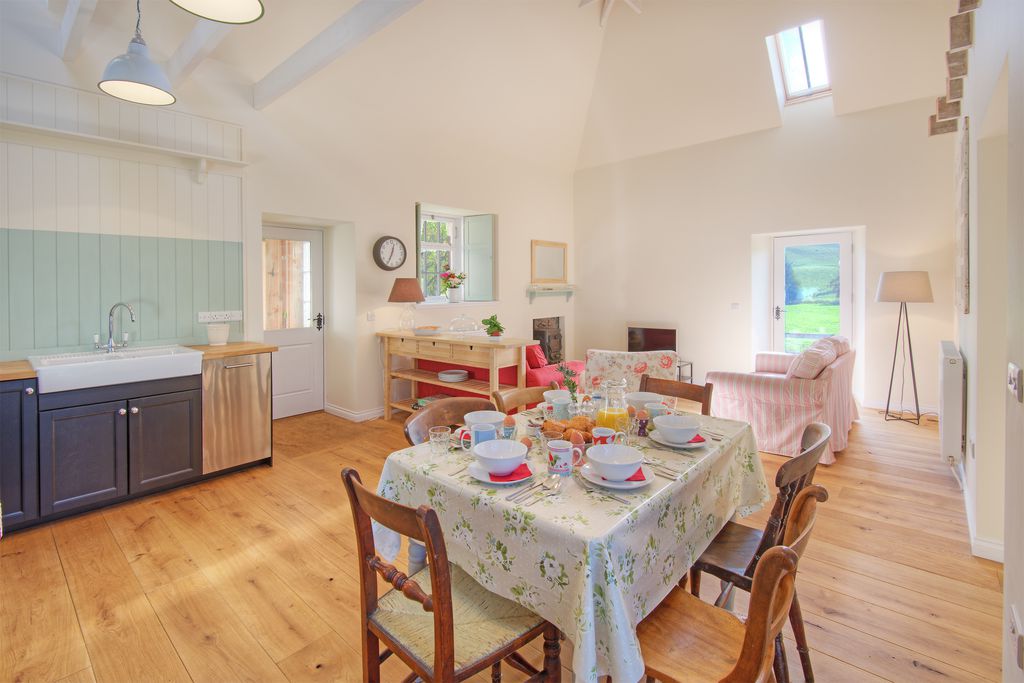 Open plan kitchen and dining area, the ktichen has modern appliances and a butlers sink