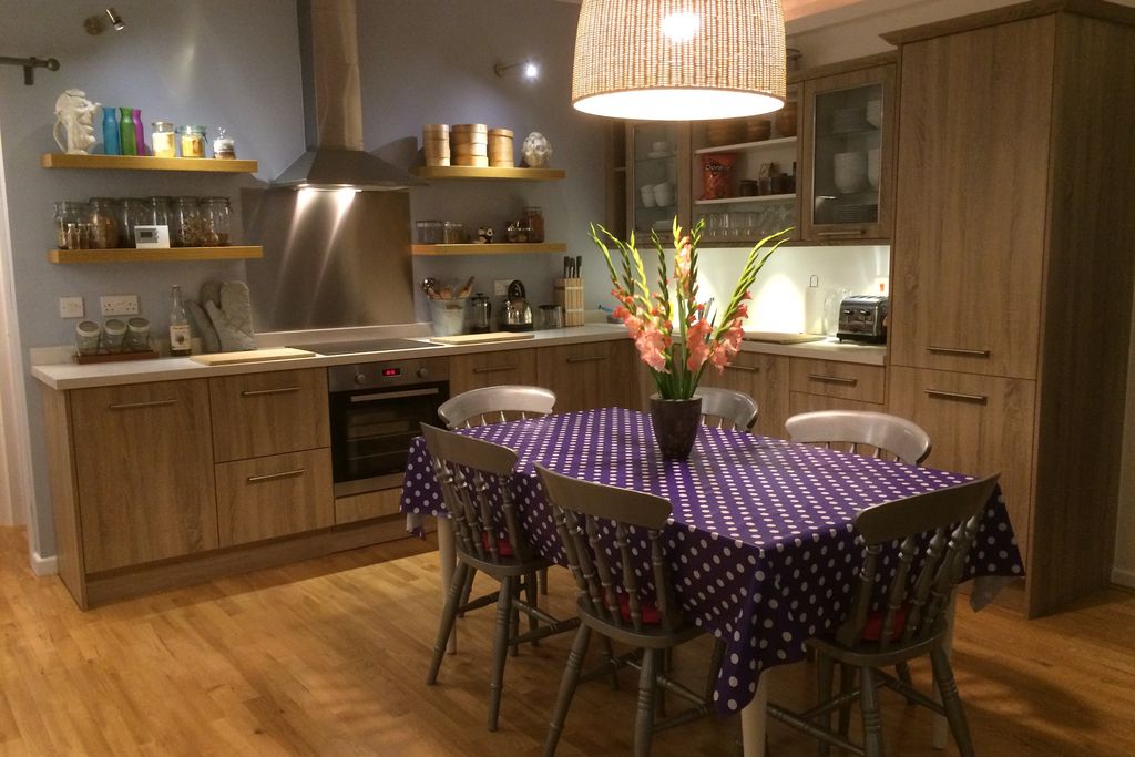 Modern kitchen with dining table and fresh flowers on the table