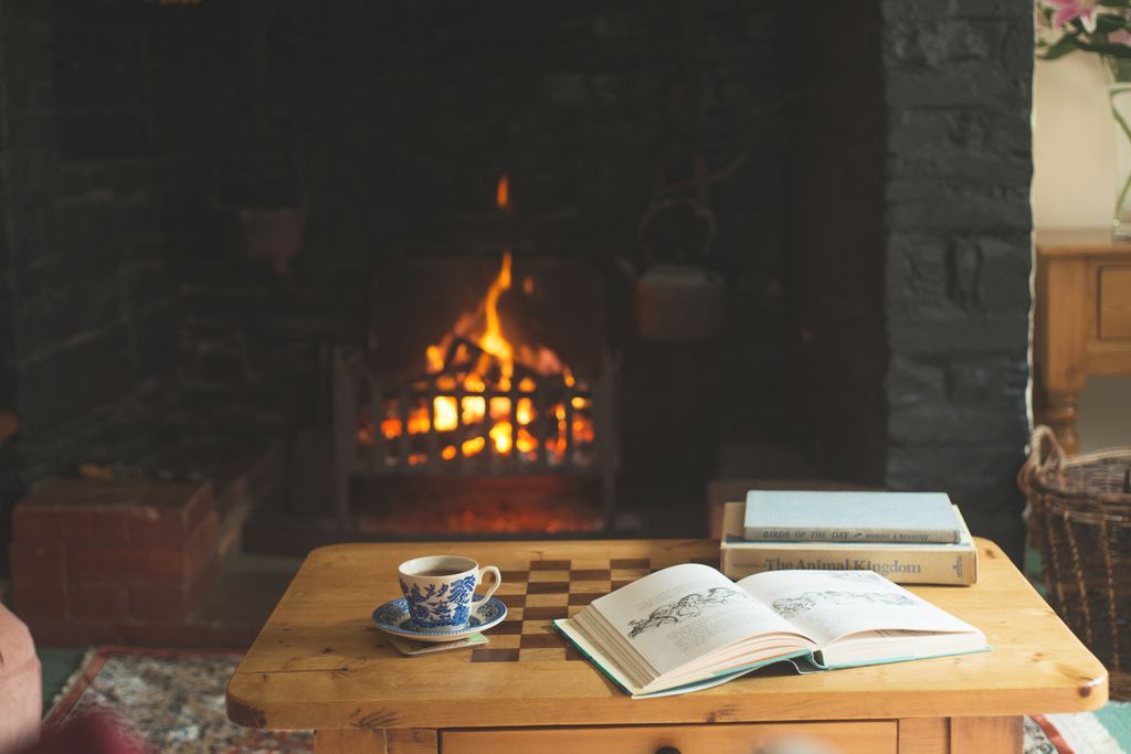 Cup of tea on the coffee table with a fire burning in the background