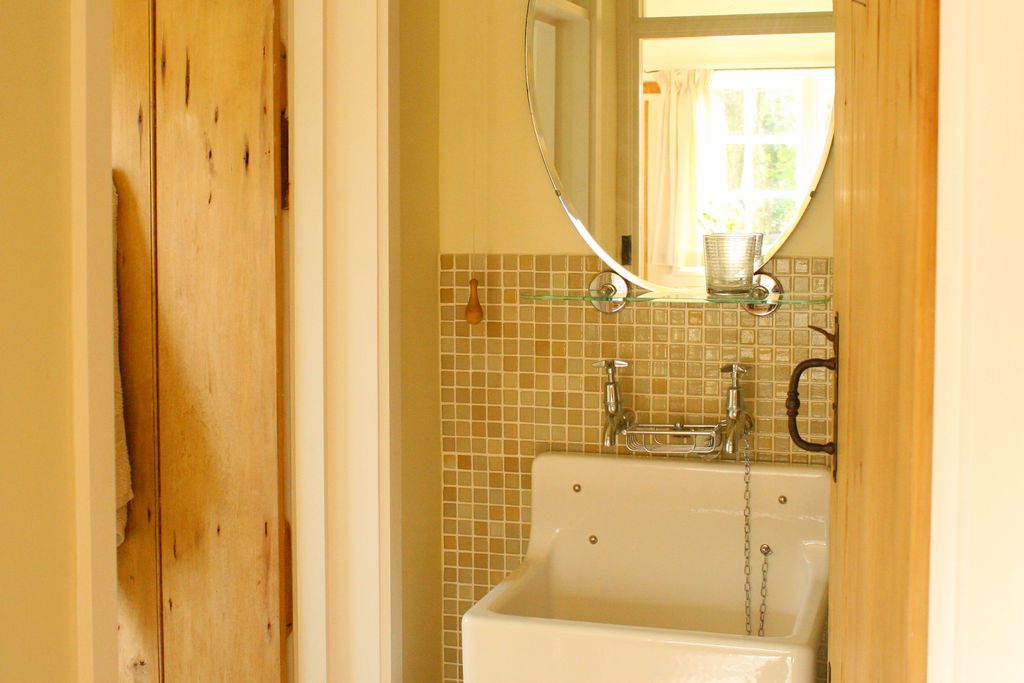 Wooden doorway leading into the bathroom with sink and mirror