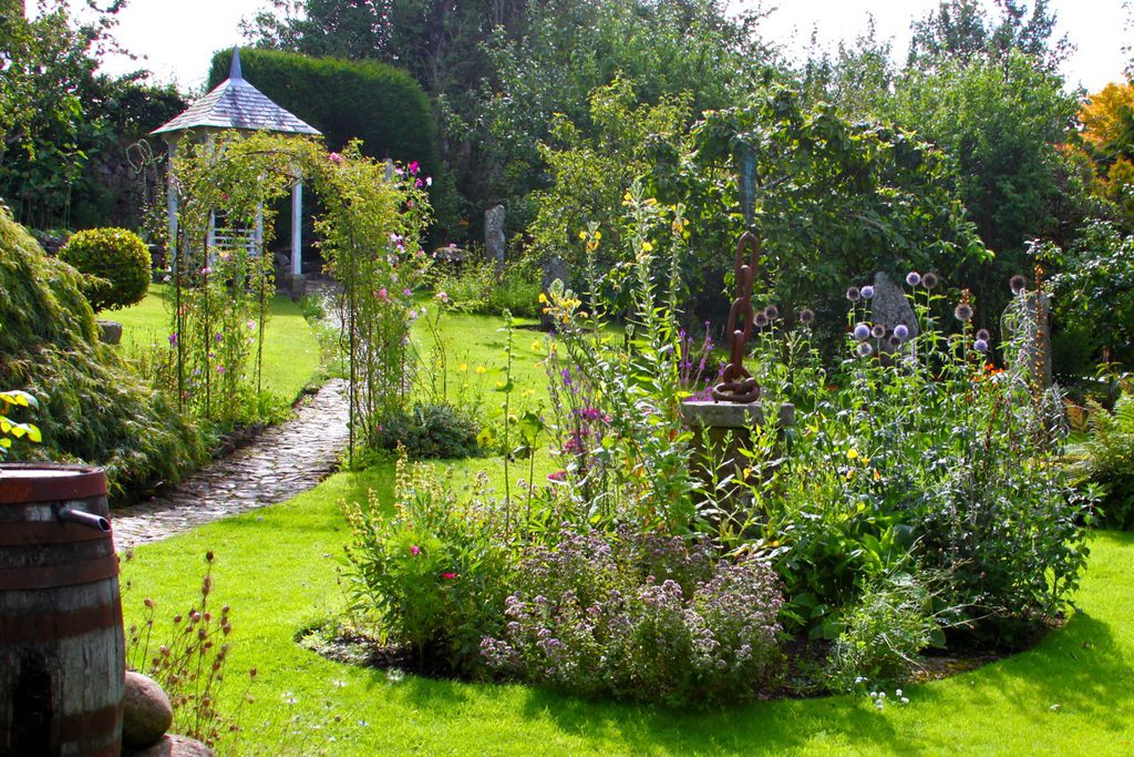 View of the lovely garden with the sculpture and pathway leading up the garden