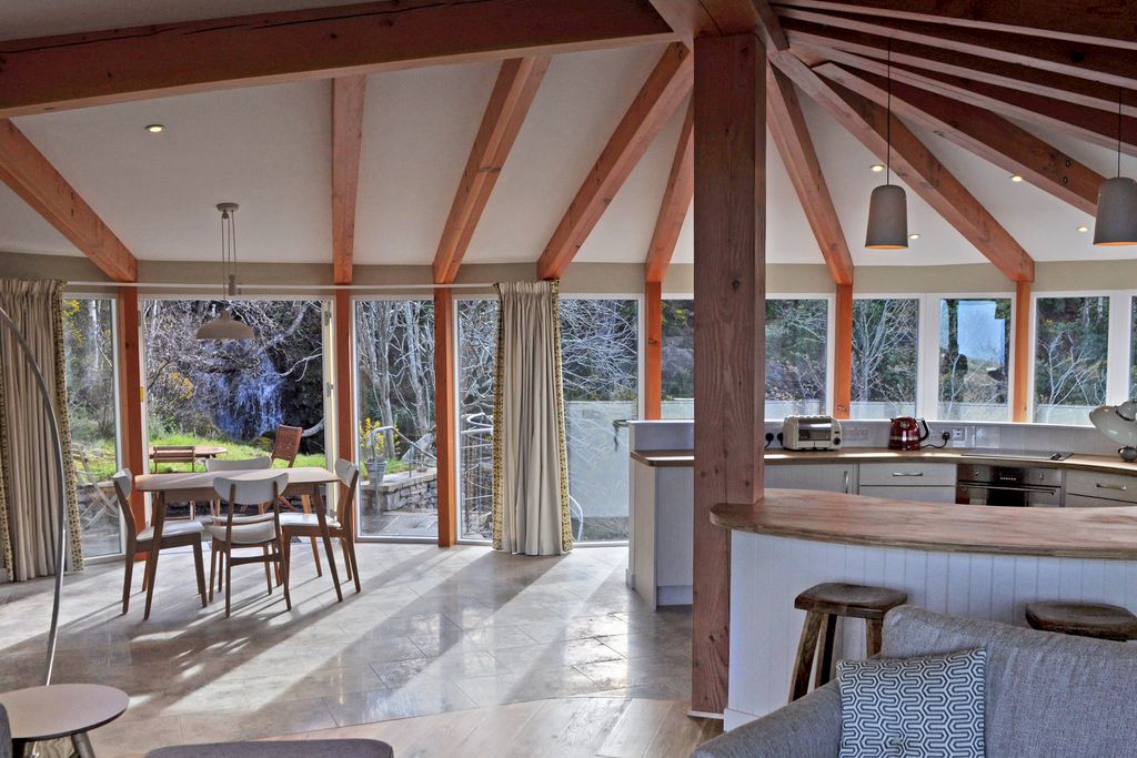 Curved kitchen looking out of floor to ceiling windows