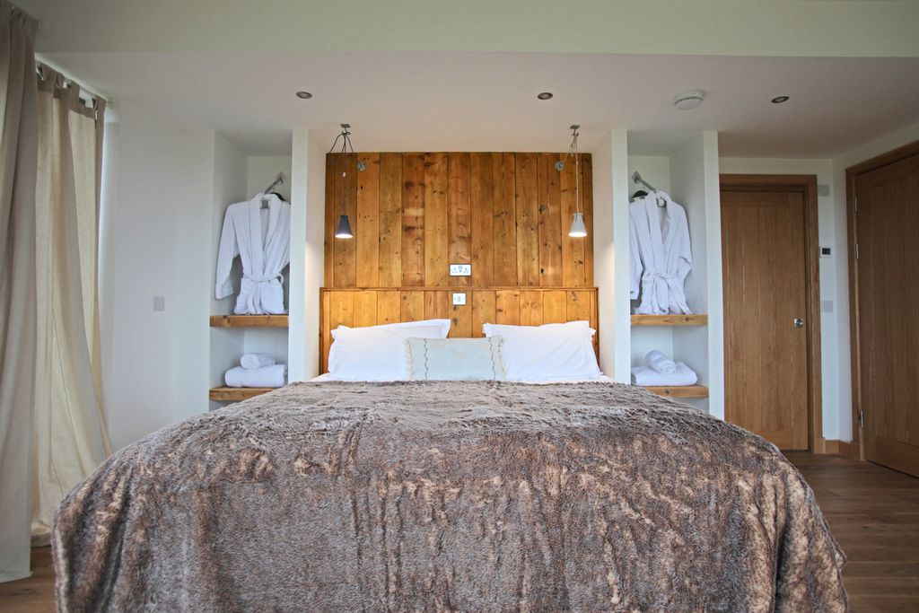 Double bedroom in a minimalist style with bath robes hanging by the bed