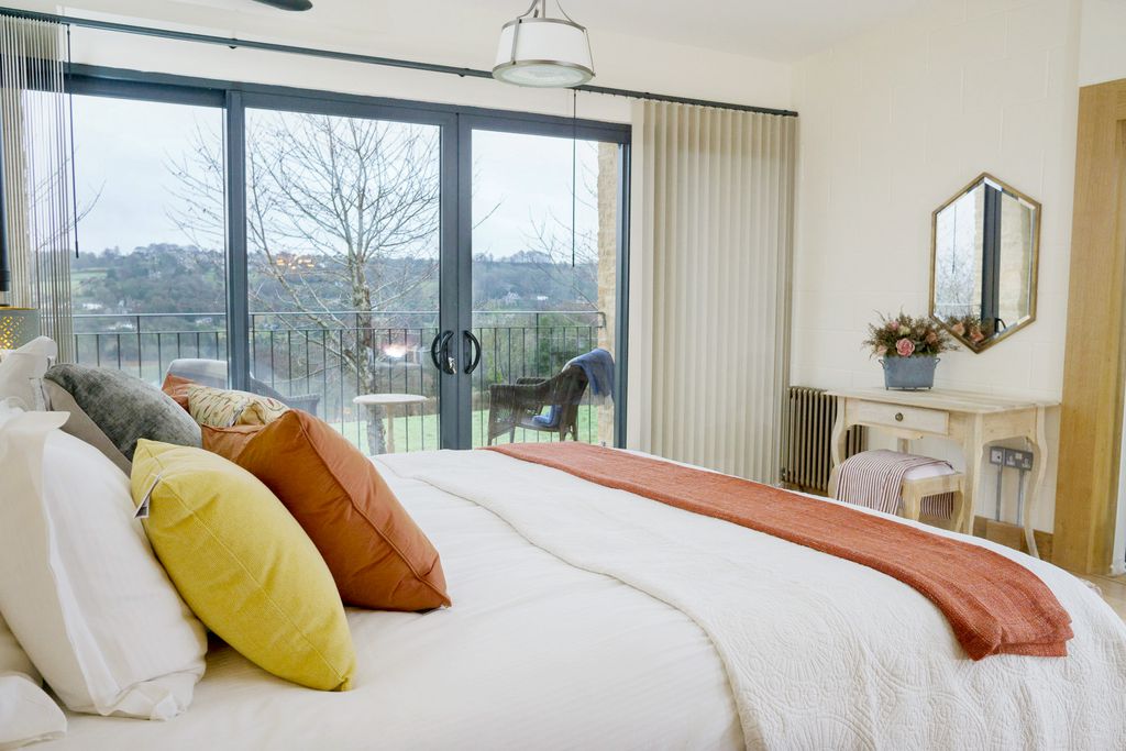 Bright bedroom with colourful touches and countryside views at Woodchester Valley Vineyard Barns near Stroud