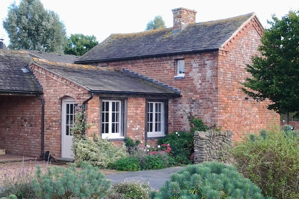 A cosy red-brick farm cottage at The Cottage at Collfryn Farm in Powys, Wales