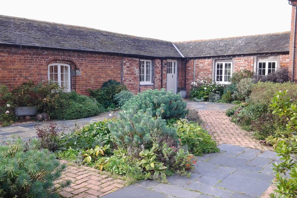 Greenery in the stone courtyard of Mill Barn cottage at Collfryn Farm in Powys, Wales