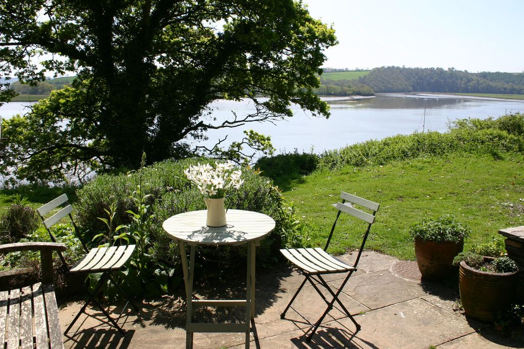 Outside seating area with flowers on the table overlooking the river