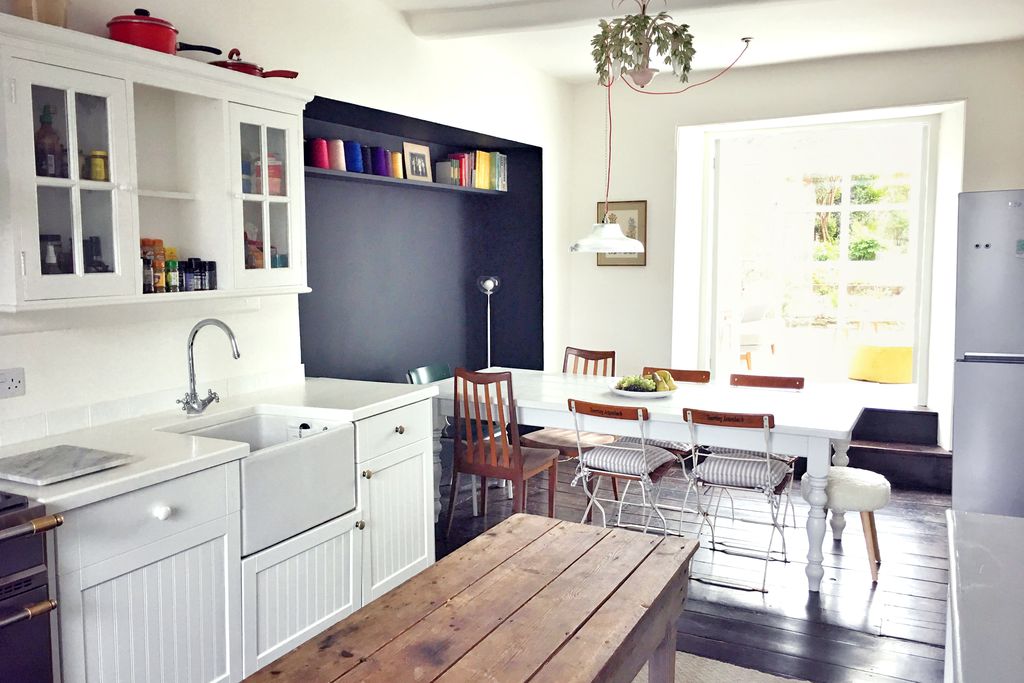 Light and airy kitchen at Sycamore House in Hay-on-Wye, Powys with large table for eight and doorway through to lounge area with view of the garden