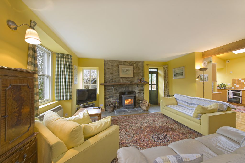 Large living room with log burner and door leading into the garden