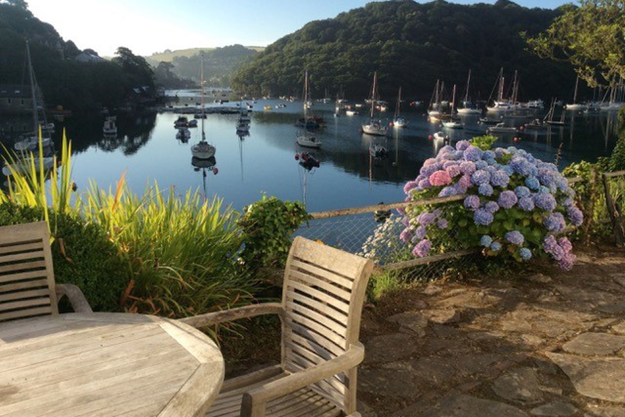 Patio with seating area overlooking the water at the Old Coastguards Cottage in Devon