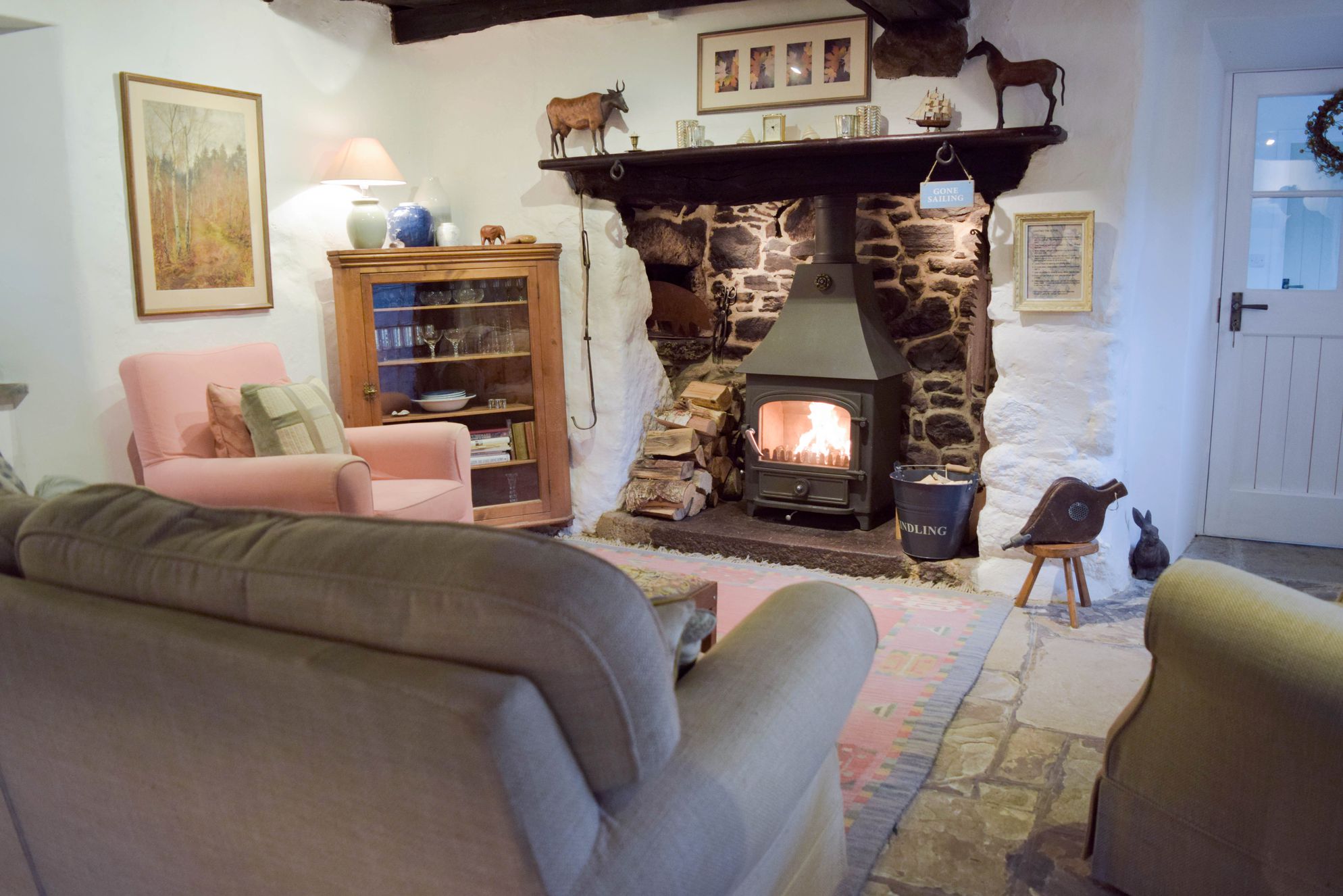 Cosy sitting room with log burner at Stares Nest Cottage in Devon