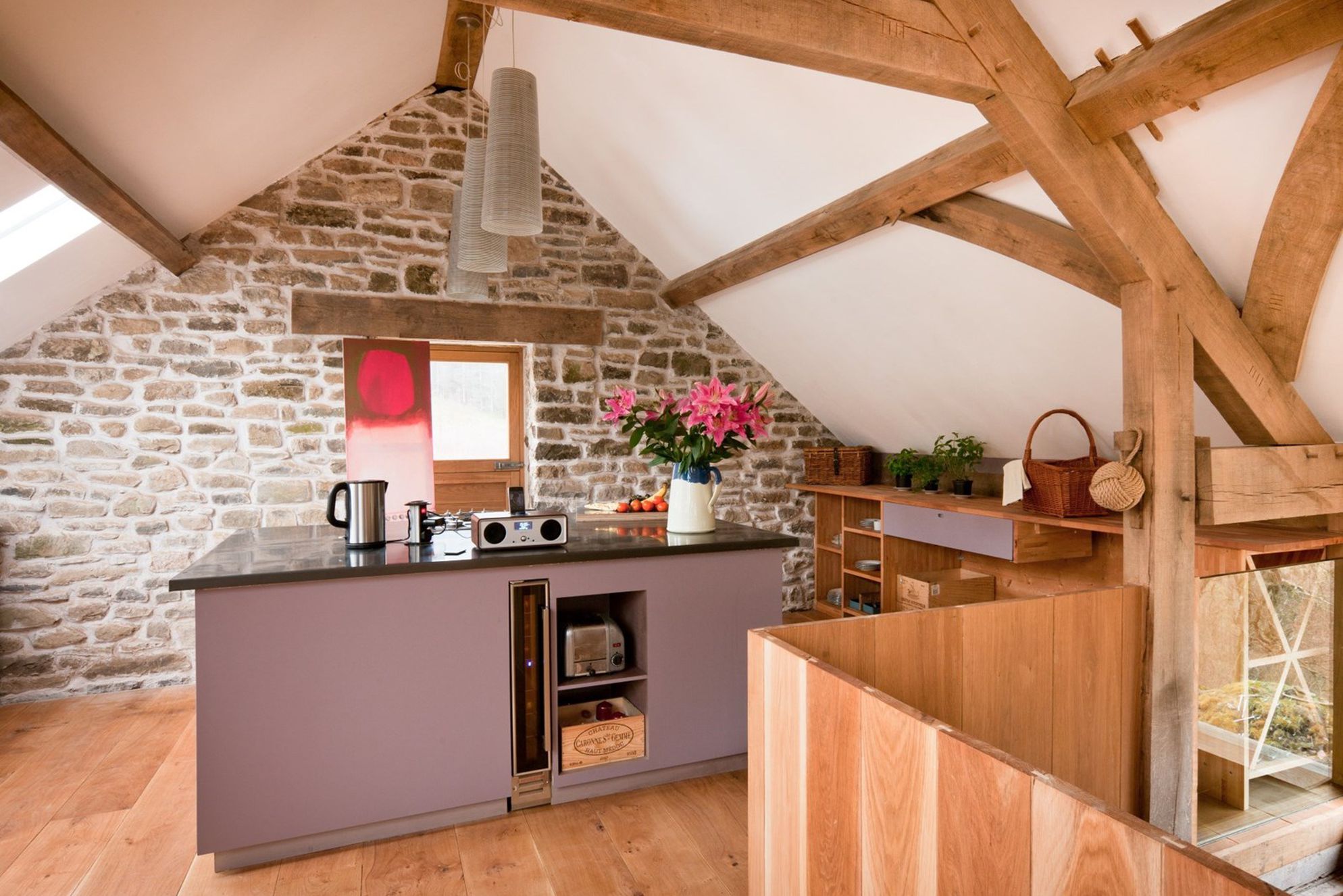 Spacious kitchen area at Red Kite Barn in Powys, Wales with nifty storage, wine cooler, coffee machine and music player