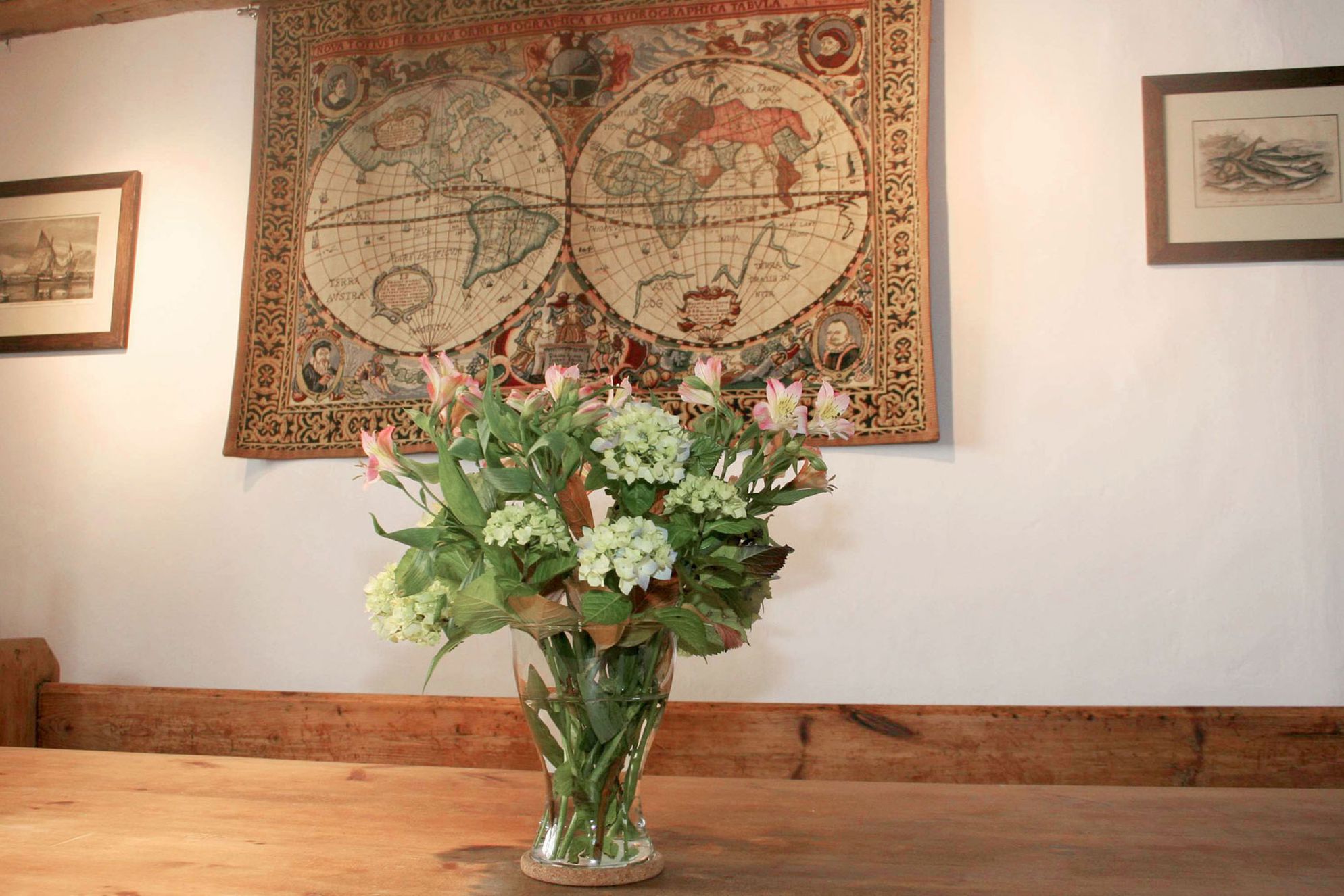 Flowers on the table with globe tapestry on the wall