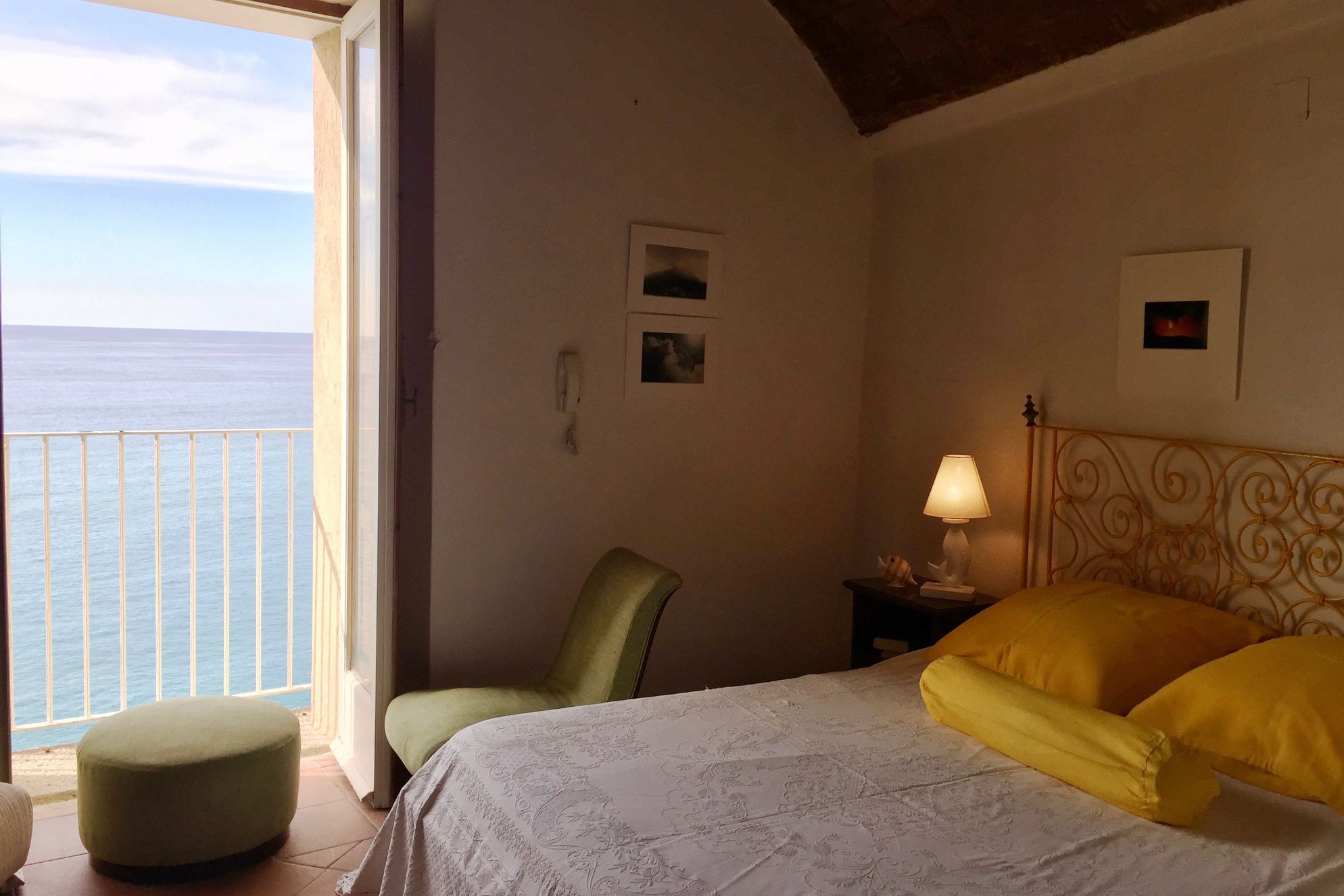 Double bed inside of Pakazzo Adilardi apartments with a balcony overlooking the sea