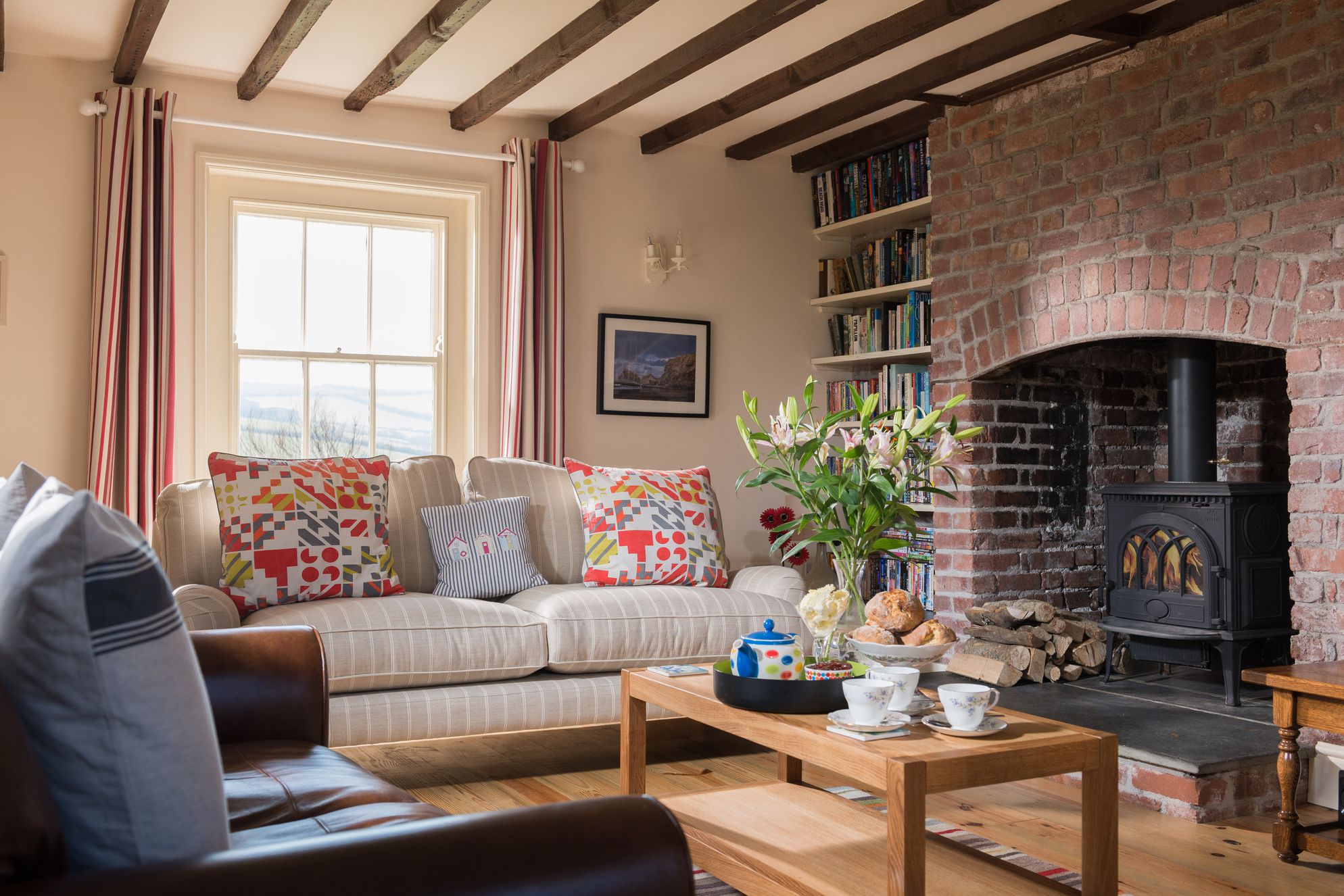Trevigue Cottage's living room with flowers tea and woodburner