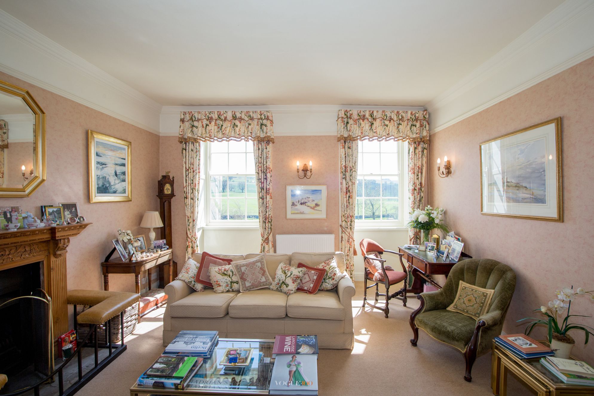 Light and sunny communal living area at Errington House with homely furnishings, open fire and lots of reading material