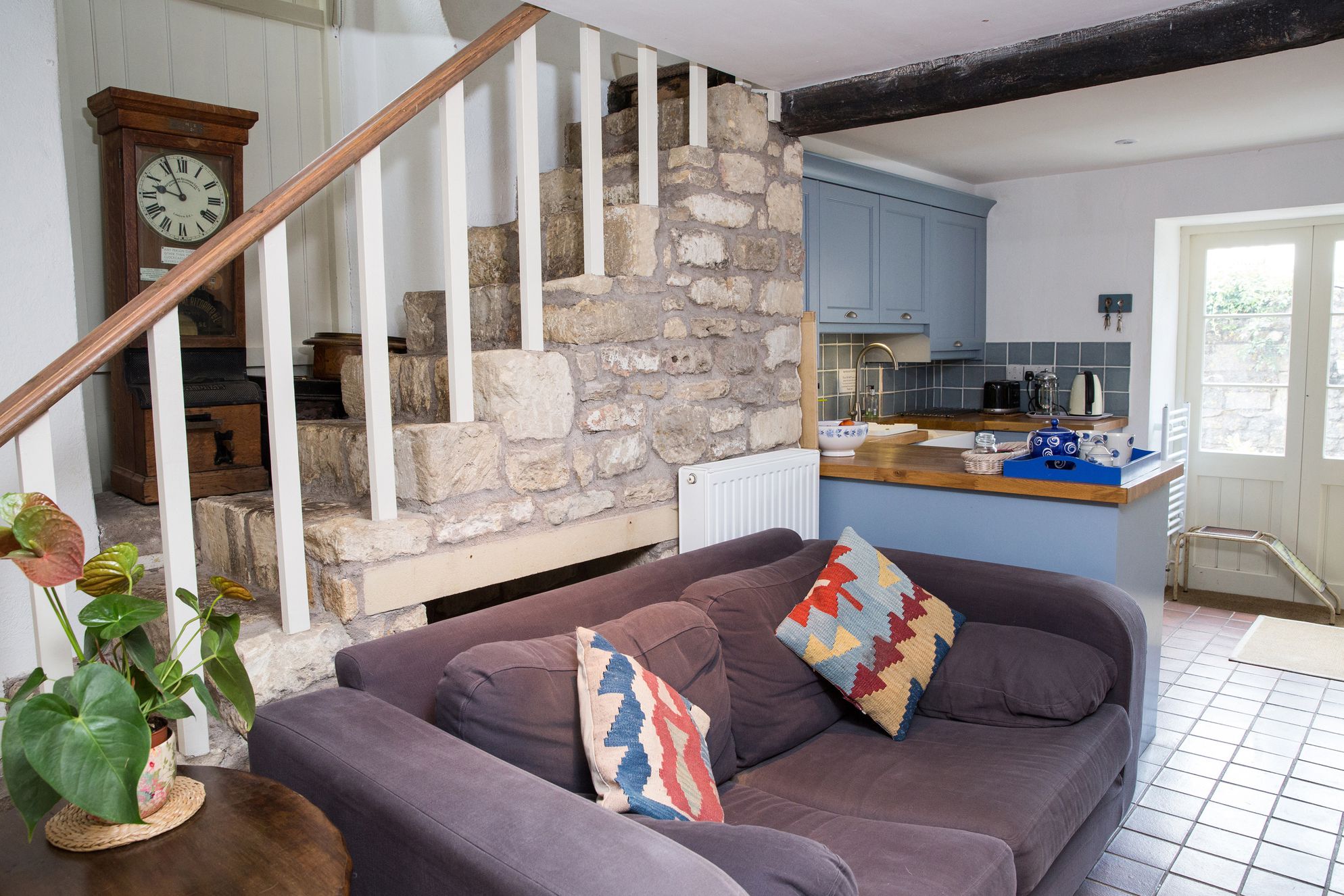 Original stone staircase with comfortable sofa in Old Dairy Barn