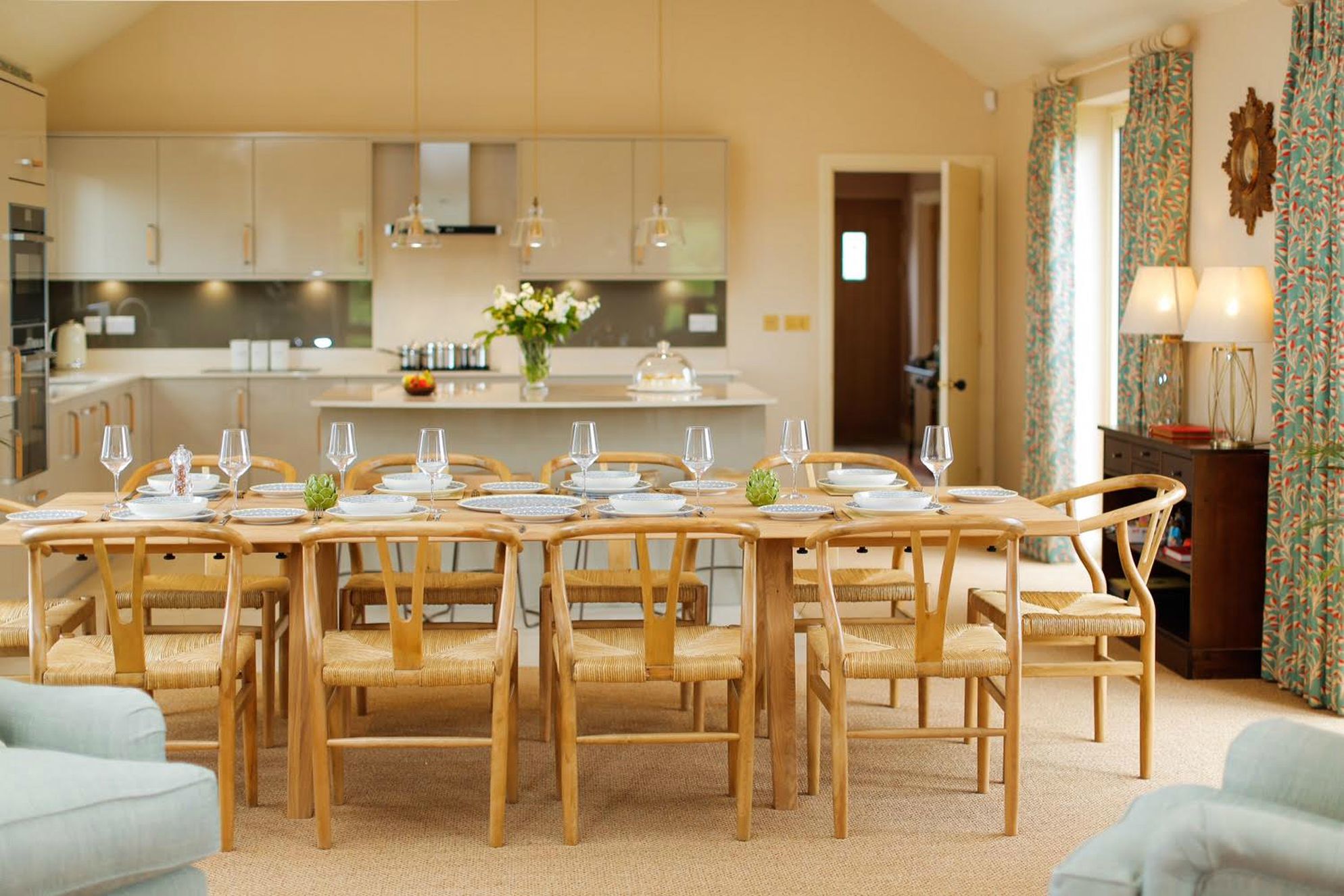 Huge dining table in Teal House Learchild with open plan kitchen behind 