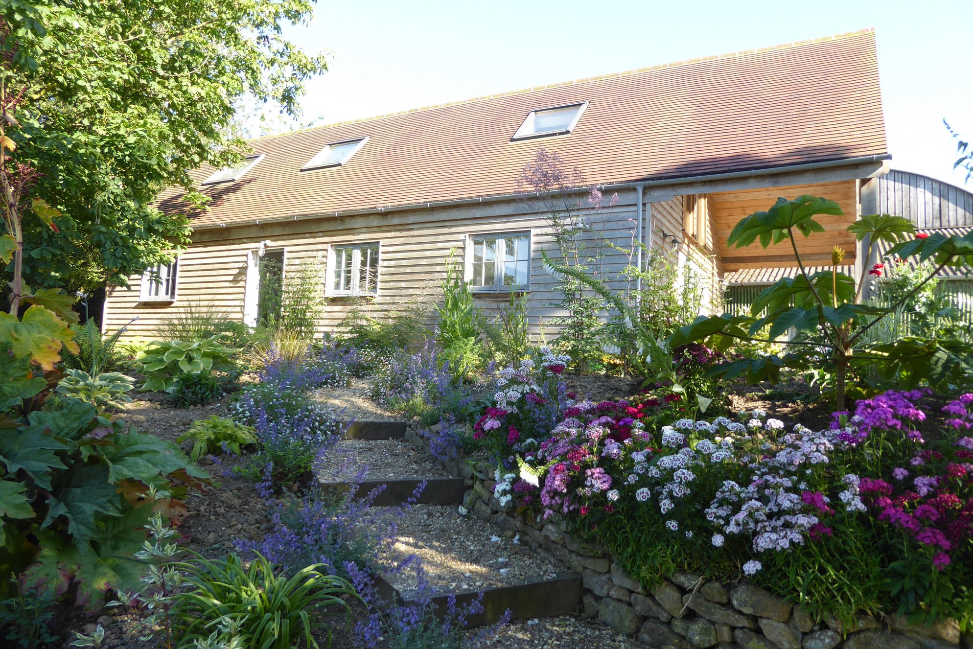 The Garden House at Holway Mill nestled in beautiful flowers in Dorset, England 